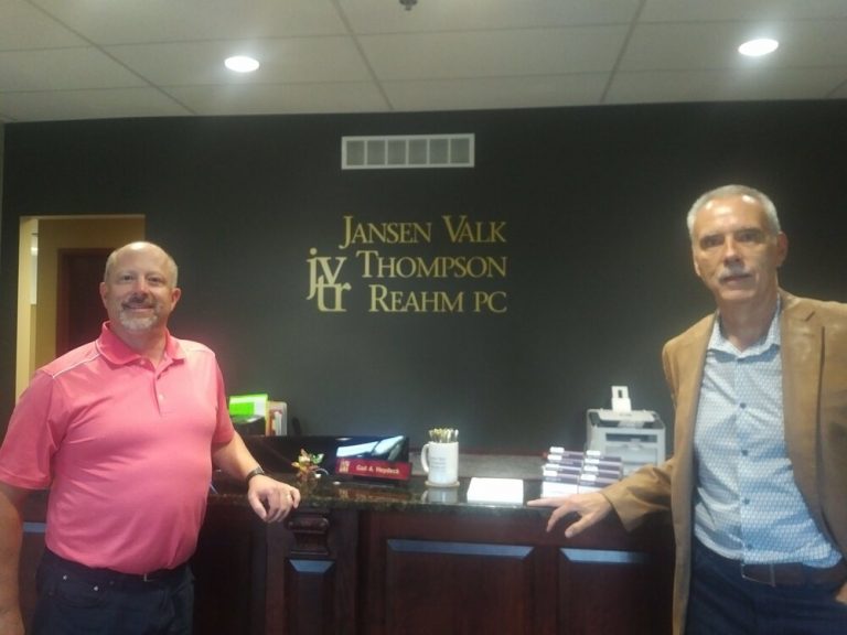 Two people standing at the Jansen Valk front desk