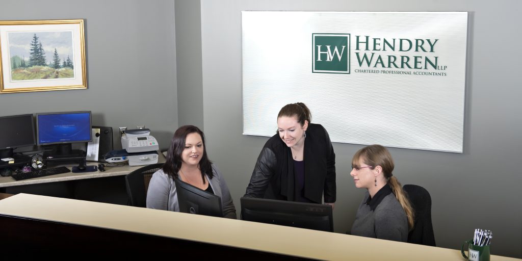 Three staff members at the front desk